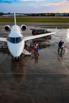 High angle view of Family boarding private plane on wet tarmac of private airport for family vacation 