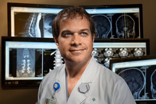 Medical professional looking off camera infront of displays with various x-rays 