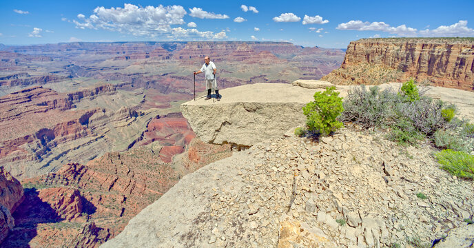 A hiker on the edge of a cliff between Moran Point and Zuni Point at Grand Canyon Arizona.