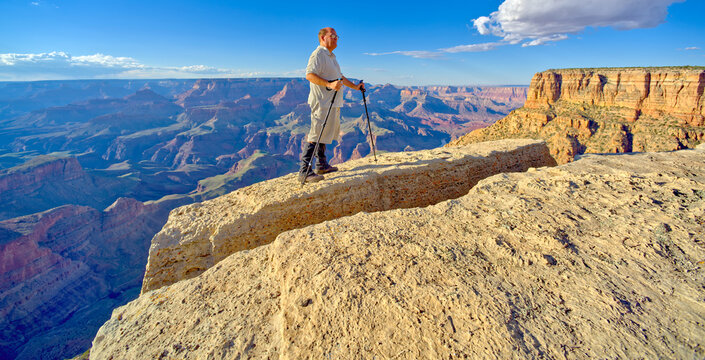 A hiker on the edge of a cliff between Moran Point and Zuni Point at Grand Canyon Arizona.