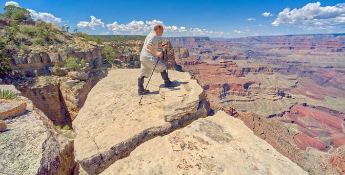 A hiker on the edge of a cliff between Moran Point and Zuni Point at Grand Canyon Arizona.
