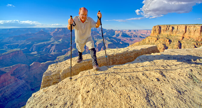 A hiker on the edge of a cliff between Moran Point and Zuni Point at Grand Canyon Arizona.