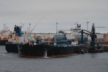 Fototapeta premium Floating storage and regasification unit. Liquified natural gas bunkering vessel and oil tanker powered by LNG in the port during the ship-to-ship operations.