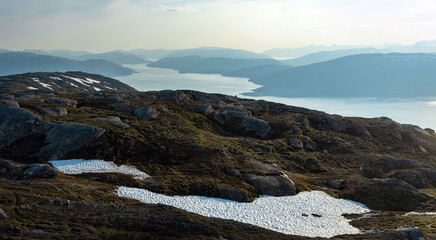 Panorama over Ranfjorden going west from Hauknestinden, 800 m altitude. Peak of Hauknes, Mo i Rana. Mountains dramatically going down into the fjord water below. Clear skies during Norwegian summer.	
