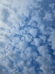 An abstract two toned background taken while looking up at a blue sky with spattered white clouds.