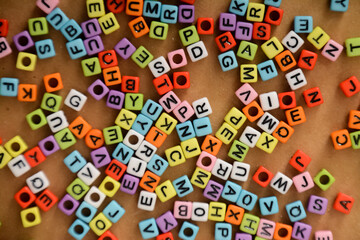 Colorful alphabet beads on wooden background.