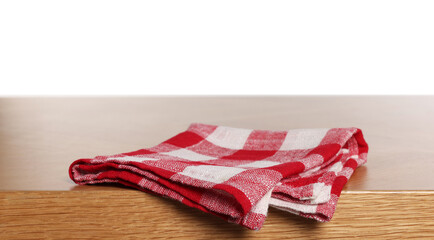 Checkered tablecloth on wooden table against white background