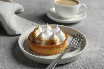 Tartlet with meringue served on light grey table, closeup. Tasty dessert