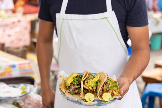 taquero mostrando tacos listos para ser entregados a los comensales