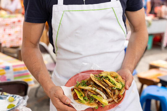 taquero mostrando tacos listos para ser entregados a los comensales