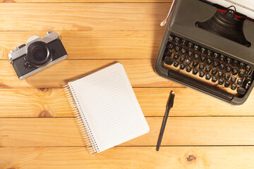 Spectacular flay lay of an old typewriter with a vintage photographic camera, notebook and pen on a...