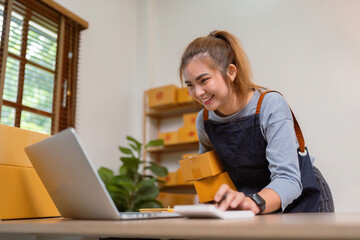 Young woman working online ecommerce shopping at her shop. prepare parcel box of product for deliver to customer