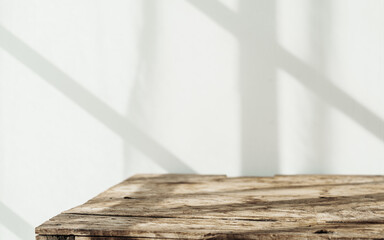 Empty tabletop with window shadow on concrete wall texture background, suitable for product presentation backdrop.