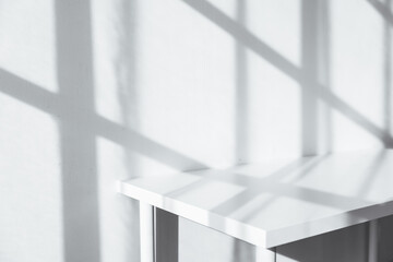 Empty tabletop with window shadow on concrete wall texture background, suitable for product...