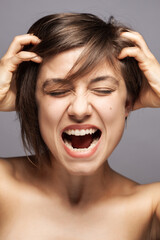 Beautiful girl fashion portrait. Surprised angry screaming face expression with hands gesture. .