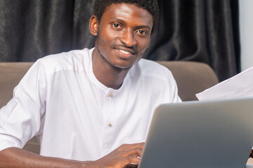 Close-up shot of a young african businessman seated and working on his laptop
