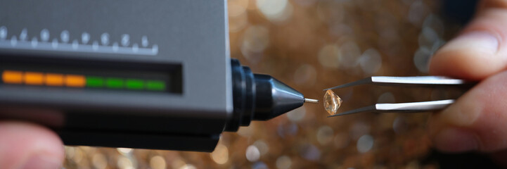 Specialist evaluates quality and cost of diamonds using special device.