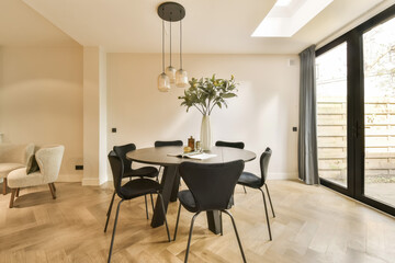 a dining room with wood flooring and glass doors leading out to the patio area, which is also open