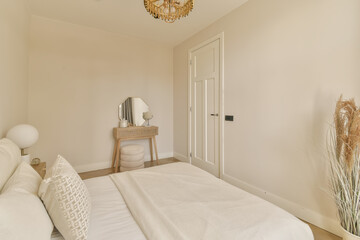 a bedroom with a bed, dresser and mirror on the wall in front of the bed is an antique chandel