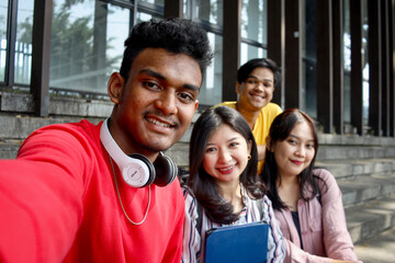 POV of Multicultural college students having fun taking selfie picture smiling using smartphone