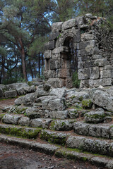 Huge stone arch in the middle of ancient ruins and ruined walls. The remains of ancient Lycia civilization, Phaselis antique city in Turkey. Mediterranean landscape