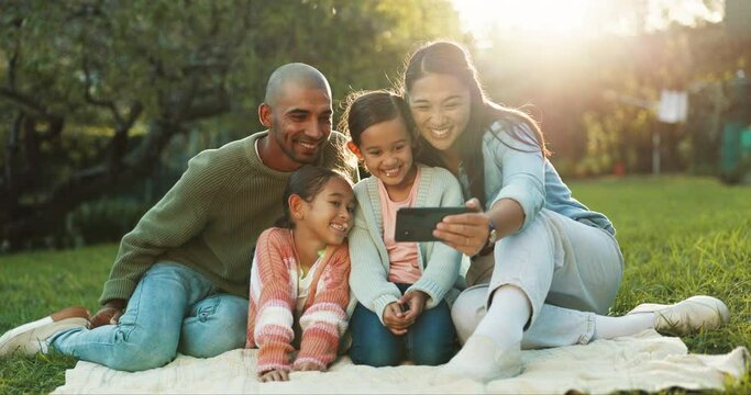 Happy family, selfie and parents on a picnic with children in a park to update social media, online or internet together. Love, care and mother relax with kids and father for quality time and bonding
