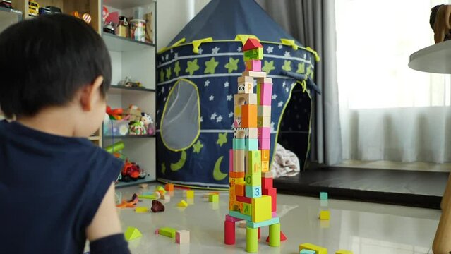 little boy build a city from many colorful wooden blocks, creative toy for design