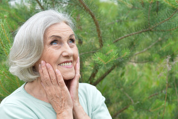 Close up portrait of happy older woman standing outside in summer