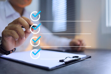 Businessman in white using pen to tick correct sign or check mark on checkbox to complete task and...