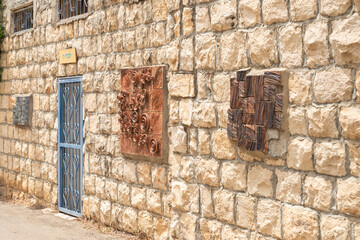 Stone wall decorated with products of local artists in the famous artists village Ein Hod near Haifa in northern Israel