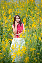 Naklejka na ściany i meble Asian woman standing among yellow flowers