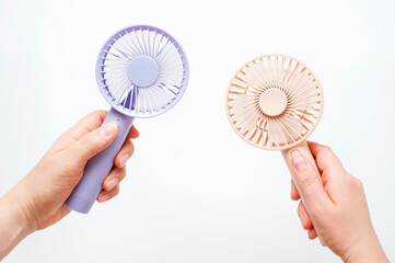 Female hands holding small fans on white background close-up.