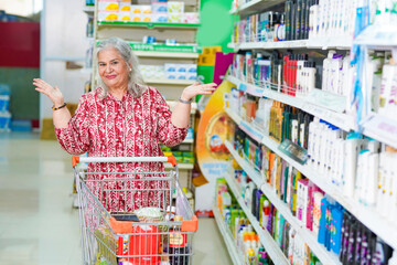 senior indian woman purchasing at grocery shop and showing happy expression.