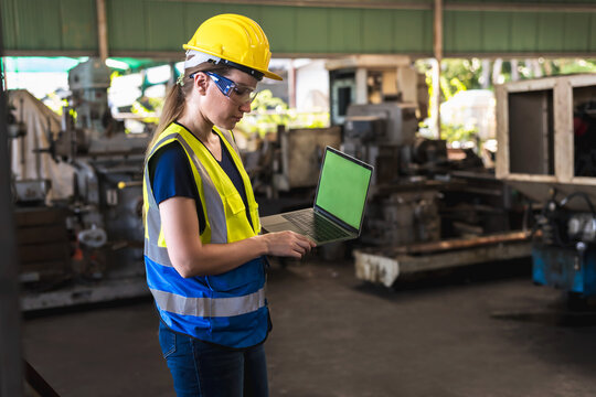 Engineer factory woman holding taplet working in heavy industrial machinery 