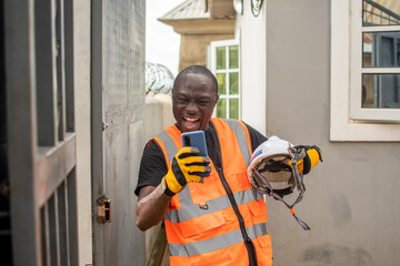 african engineer feeling happy checking his phone