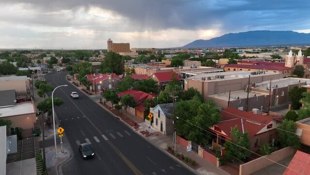 Vibrant housing in suburb of Albuquerque, New Mexico. Aerial rising shot of houses and homes as thunderstorm rolls in over mountains.