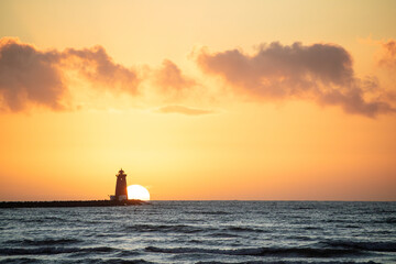 Sun rising behind a lighthouse, beautiful sunrise