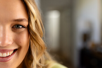 Portrait of happy caucasian woman with long blond hair at home, copy space