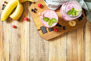 Raspberries, bananas and black currant. Set of fresh various delicious milkshakes or smoothies with fresh berries. View from above. Copy space.
