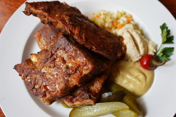 Ribs in spicy marinade with chili, honey, sour cabbage, pickle cucumber and mustard