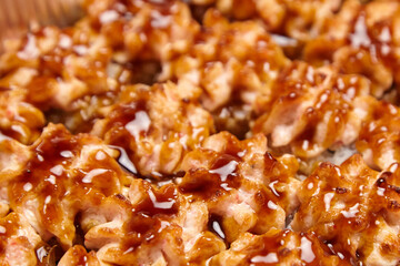 Baked sushi rolls texture background, closeup. Topped hot sushi rolls with different fillings. Exquisite baked sushi rolls