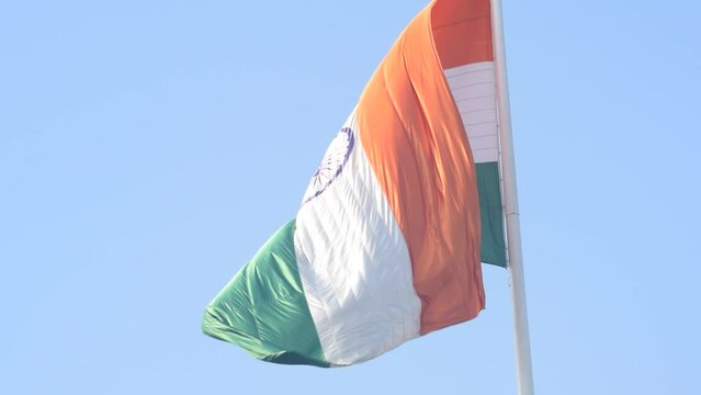 India flag flying high at Connaught Place with pride in blue sky, India flag fluttering, Indian Flag on Independence Day and Republic Day of India, tilt up shot, Waving Indian flag, Har Ghar Tiranga