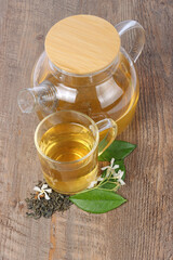 mug of jasmin tea isolated on wooden background 