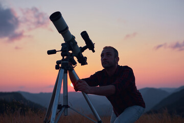 Astronomer looking at the skies with a telescope.