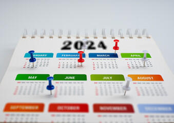 2024 Calendar planning. colorful pin thumbtack date on calendar or planner. 2024 planning and scheduling or event reminder concept. pins on calendar event