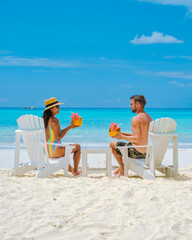 couple men and women on the beach with a coconut drink Praslin Seychelles tropical island with...