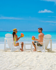 couple men and women on the beach with a coconut drink Praslin Seychelles tropical island with white beaches and palm trees, the beach of Anse Volbert Seychelles.