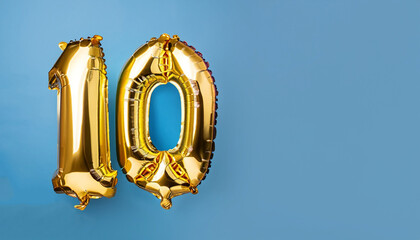 Banner with number 10 golden balloon with copy space. Ten years anniversary celebration concept on a blue background.