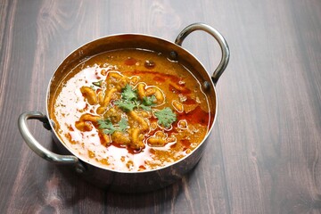 Traditional Sev bhaji or sev tamatar nu Shaak with Jowar Bhakri. Sev is a crisp fried gram flour vermicelli. Served with chopped onion and lemon. with Copy space. Its a sweet and spicy indian curry.