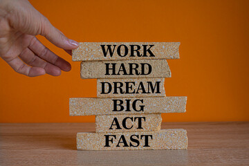 Work hard dream big symbol. Words Work hard dream big act fast on brick blocks on a beautiful...